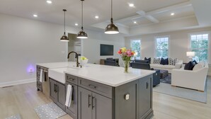 A spacious kitchen with a large island, dark gray cabinets, and pendant lighting. - Beach House w/ Deck & Pool Access in Rehoboth (Rehoboth Beach)