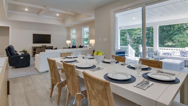 A spacious dining area with a large table set for six, surrounded by wicker chairs. - Beach House w/ Deck & Pool Access in Rehoboth (Rehoboth Beach)