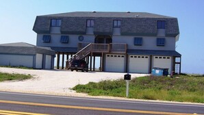 A two-story building with a covered entrance and a staircase leading to the upper level. - Boardwalk #3: Beachfront + Free Daily Admissions | Pet Friendly (Pensacola)