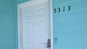 A white door with a keypad lock, a mailbox, and the number 5313 on the wall. - 3BR Coastal Cottage | Deck + Grill (Pensacola)