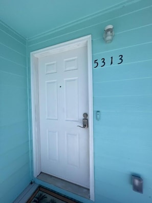 A white door with a keypad lock, a mailbox, and the number 5313 on the wall. - 3BR Coastal Cottage | Deck + Grill (Pensacola)