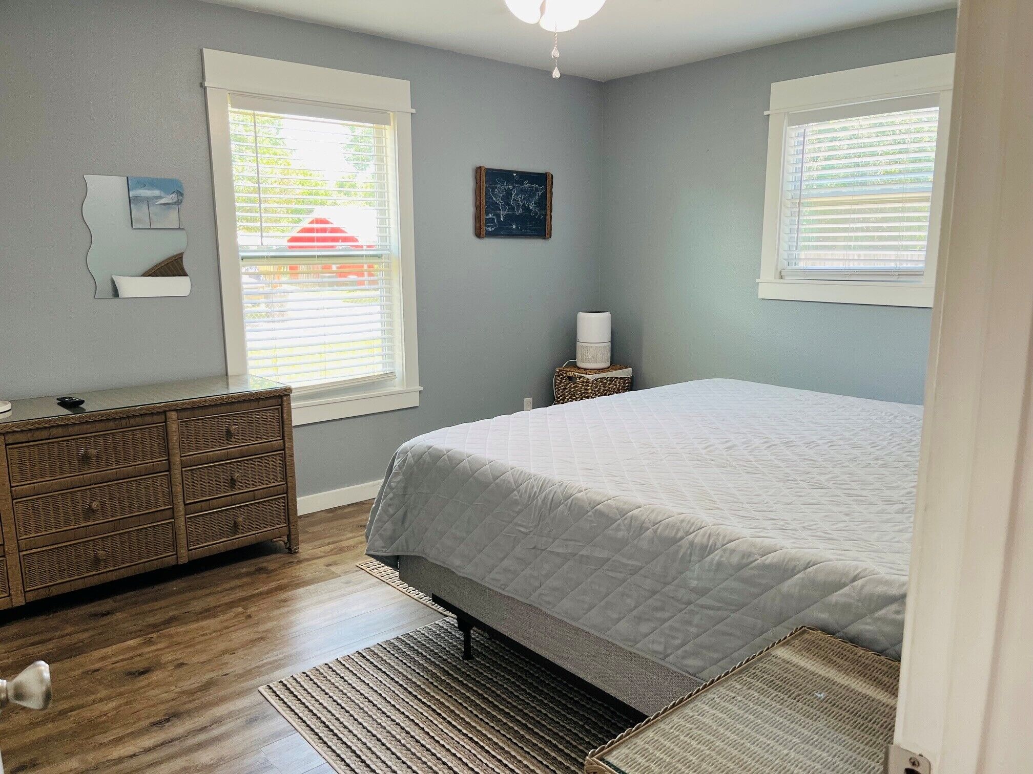 Une chambre à coucher avec un lit, une commode et une petite table avec une lampe.