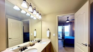 A bathroom with two sinks, a large mirror, and a ceiling light fixture.
