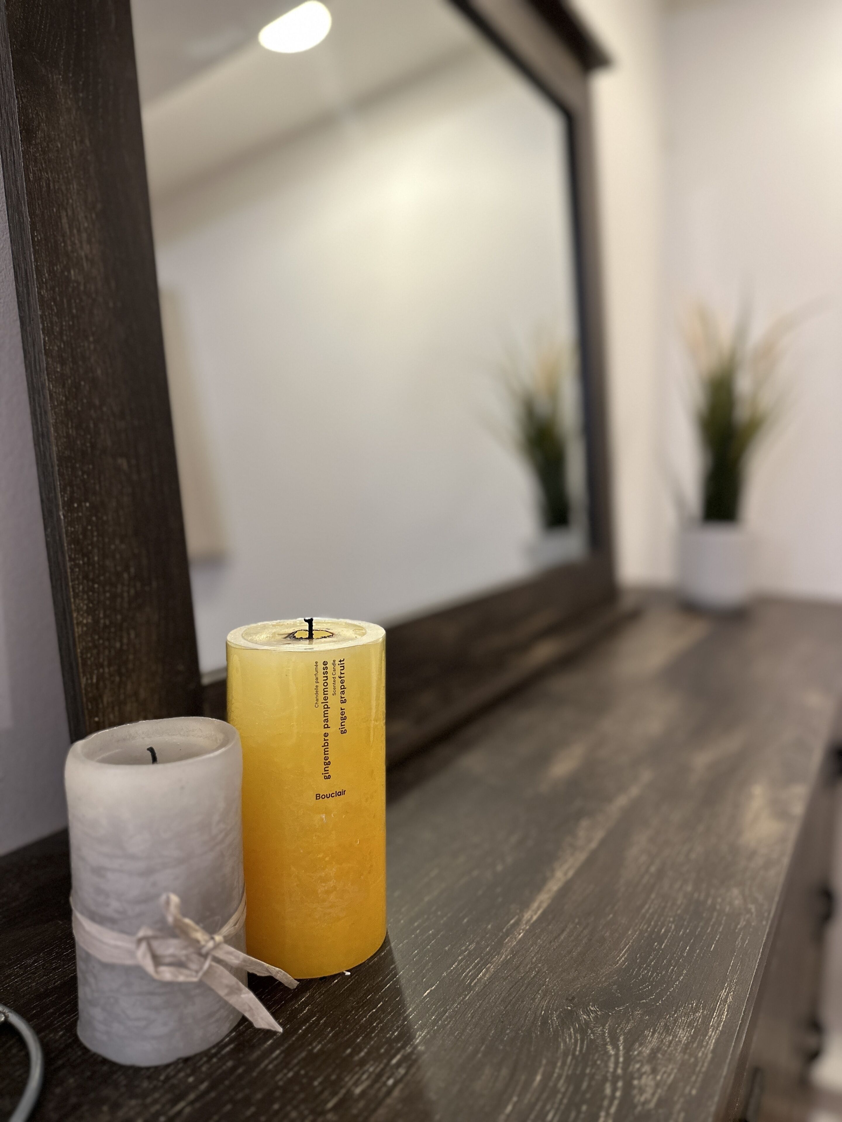 A candle holder with a candle on a wooden surface.