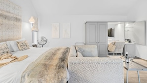 Une chambre à coucher moderne avec un grand lit, un bureau et une armoire.