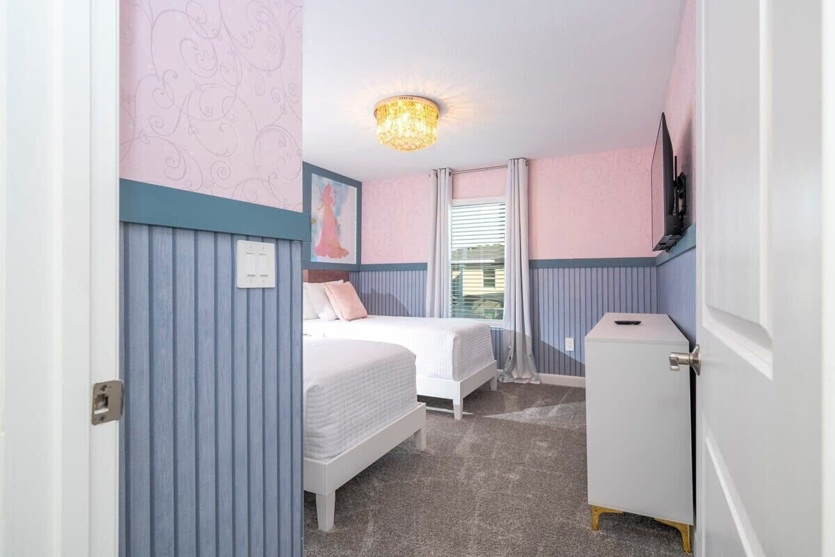 A bedroom with two beds, a ceiling light, a TV, and a small cabinet.