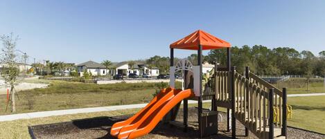 A playground with a slide and a climbing structure.