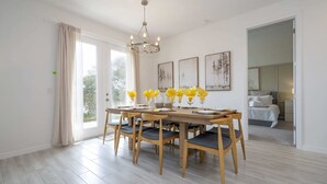 A dining area with a wooden table and chairs, a chandelier, and artwork on the walls. - Gorgeous 4Bd W/ Gameroom Close To Disney @ Glen West Haven 2198 (Davenport)