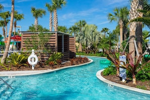 A swimming pool with a wooden structure, palm trees, and a lifebuoy. - Gorgeous 5Bd W/ Pool At Windsor Island Resort 3882 (Davenport)