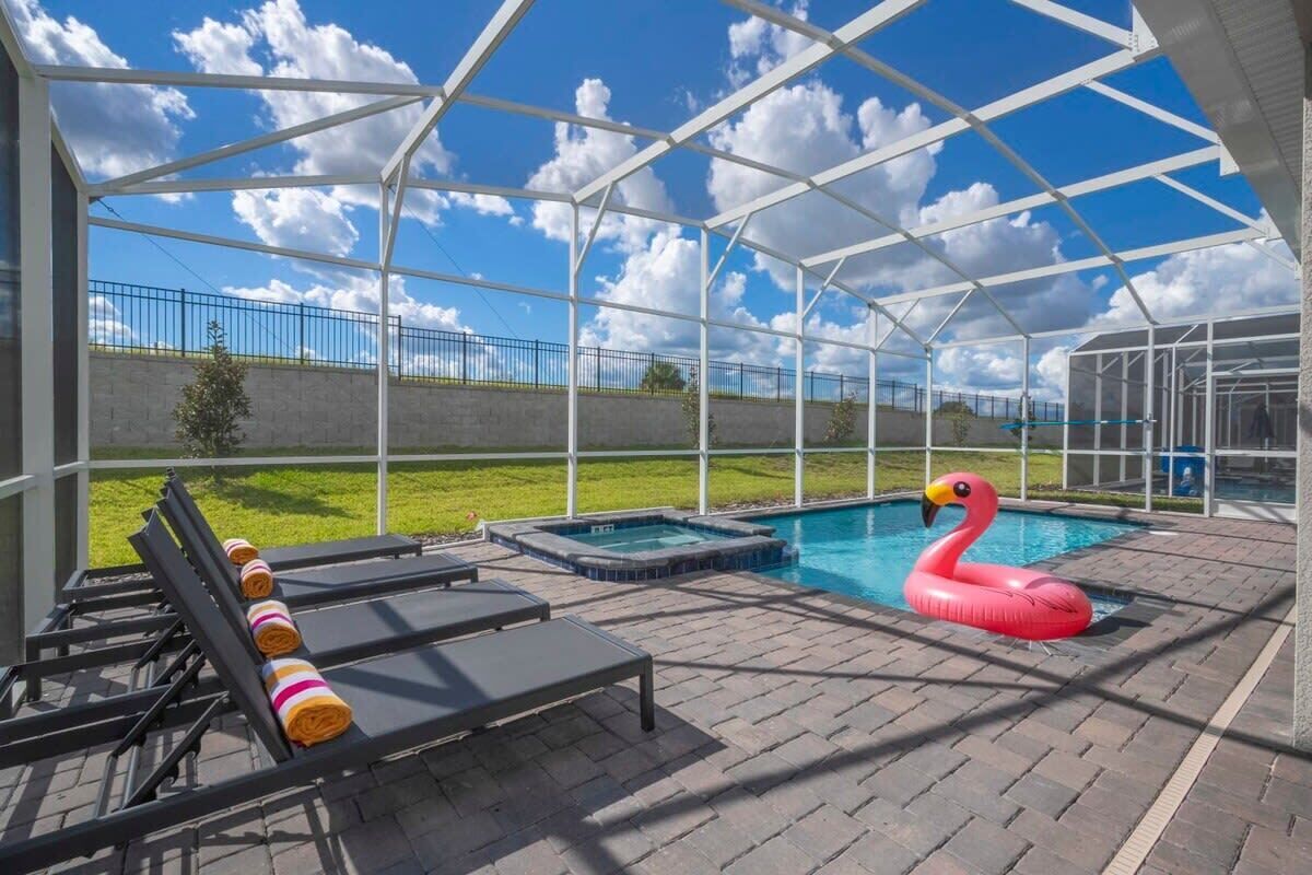Un espacio al aire libre techado con sillones de descanso, un jacuzzi y una piscina.
