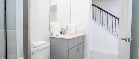 A bathroom with a toilet, sink, and mirror.