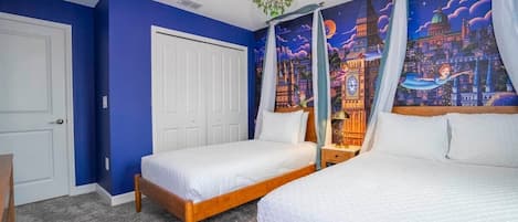 Une chambre avec deux lits, dont un lit à baldaquin, une fresque représentant un paysage urbain et un lustre.