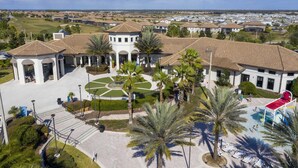A residential area with a central courtyard, palm trees, and a swimming pool.