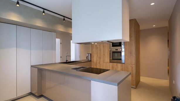 A modern kitchen with a central island, stainless steel appliances, and a minimalist design. - Hippocrates - Faliro Deluxe Apartment (Palaio Faliro)