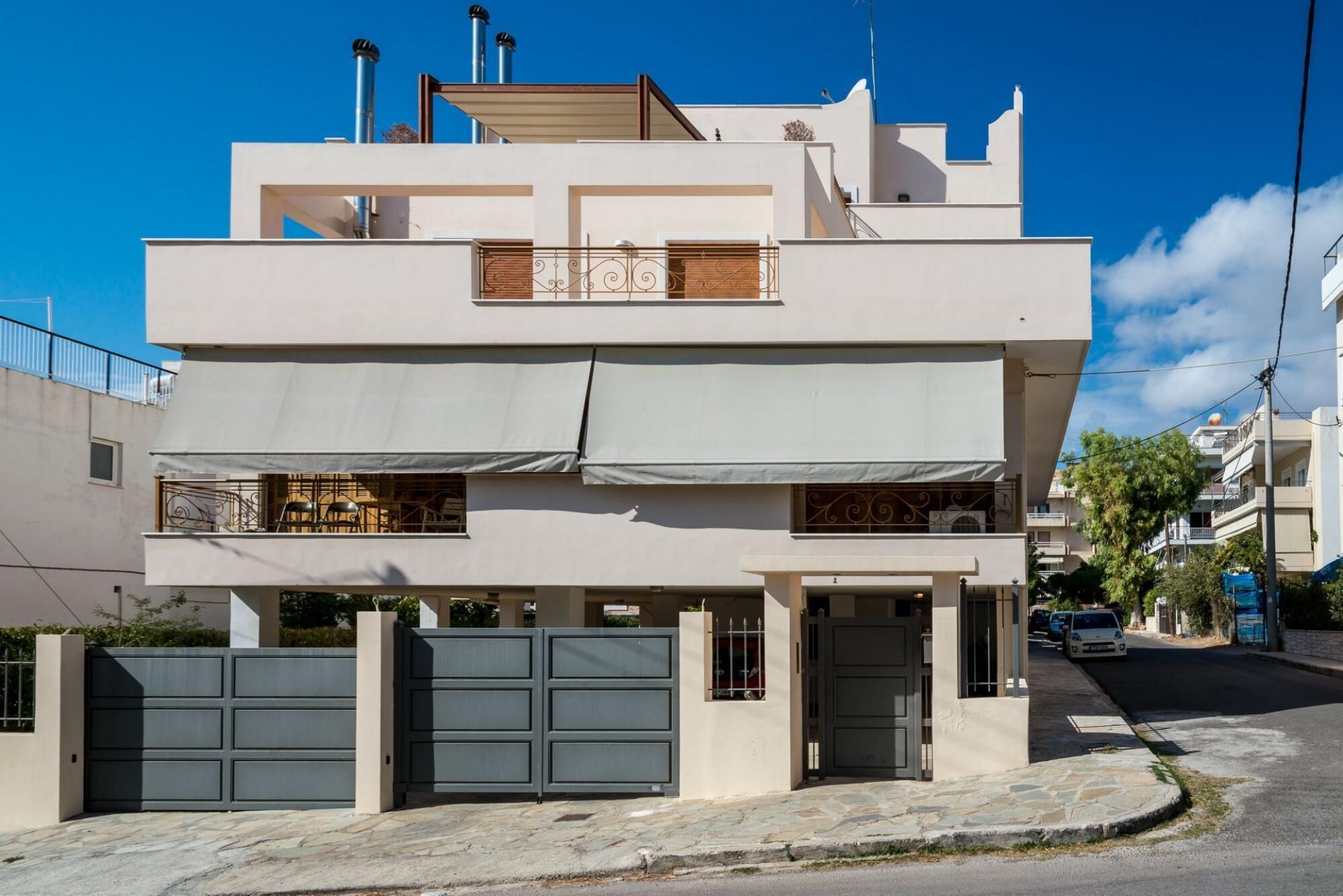 Una casa moderna a due piani con tetto piatto, un balcone al piano superiore e un garage nella parte anteriore.