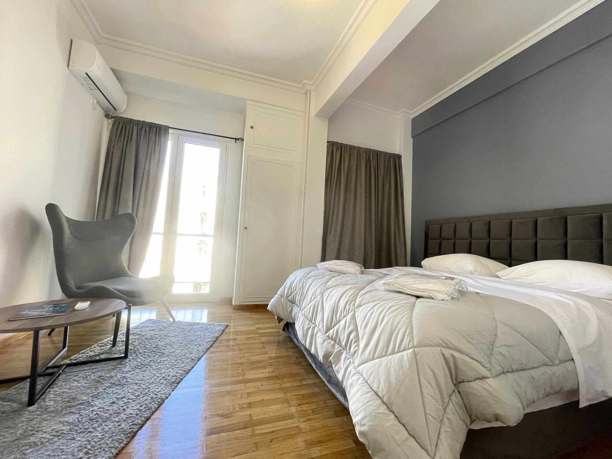 Une chambre à coucher avec un lit, une chaise, un bureau et une fenêtre.