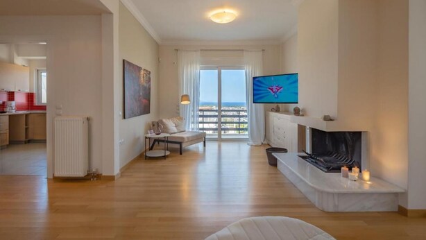 Un salon moderne avec une cheminée, un téléviseur et un balcon offrant une vue agréable.