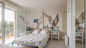 Une chambre à coucher avec un lit, des tables de chevet, un miroir et un balcon.