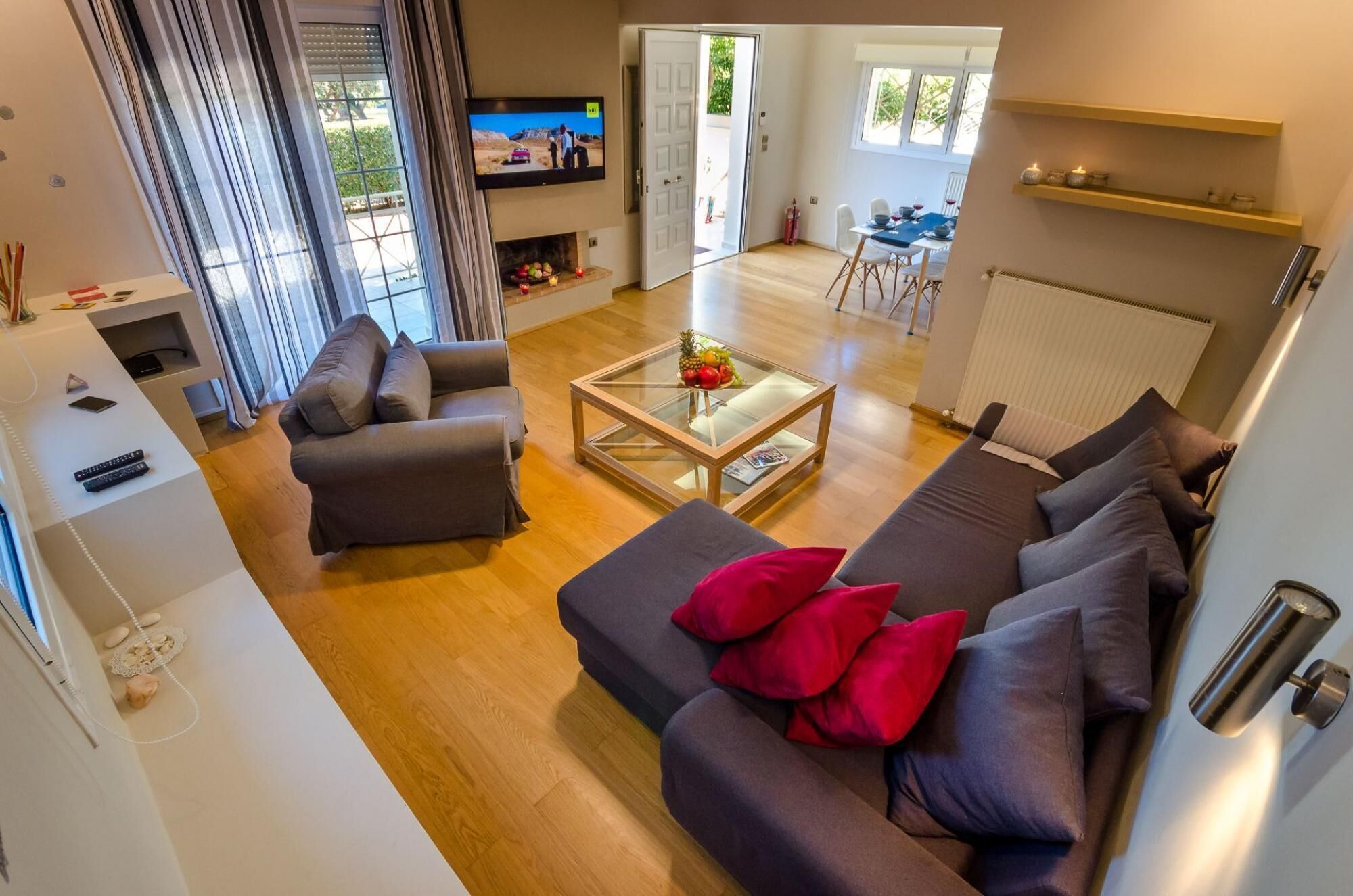 A modern living room with a sofa, armchairs, and a glass coffee table.