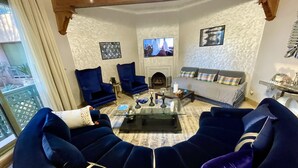 Ein Wohnzimmer mit einer großen Couch, zwei Sesseln, einem Couchtisch und einem Kamin.