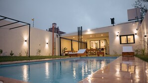 A swimming pool with lounge chairs and a patio area. - Sumérgete en el Lujo, en una Ubicación Inigualable. ¡Tu Escape Perfecto! (San Rafael)