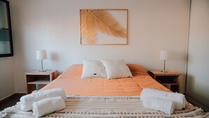 A neatly made bed with two pillows, a white throw blanket, and two towels on a textured rug. - Sumérgete en el Lujo, en una Ubicación Inigualable. ¡Tu Escape Perfecto! (San Rafael)