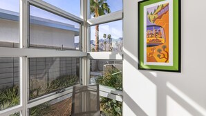 A modern room with large windows, a view of palm trees, and a framed picture on the wall. - Come visit Palm Springs! (Palm Springs)