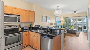 A modern kitchen with stainless steel appliances, wooden cabinets, and a large island.