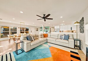 A modern living room with a sectional sofa, a coffee table, and a colorful rug.