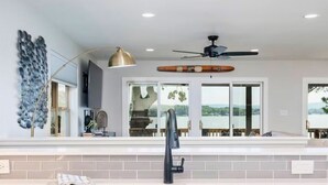 A modern kitchen with a large window, a ceiling fan, and a built-in oven. - Lakeside | Hot Tub | Private Dock | Views (Hot Springs)