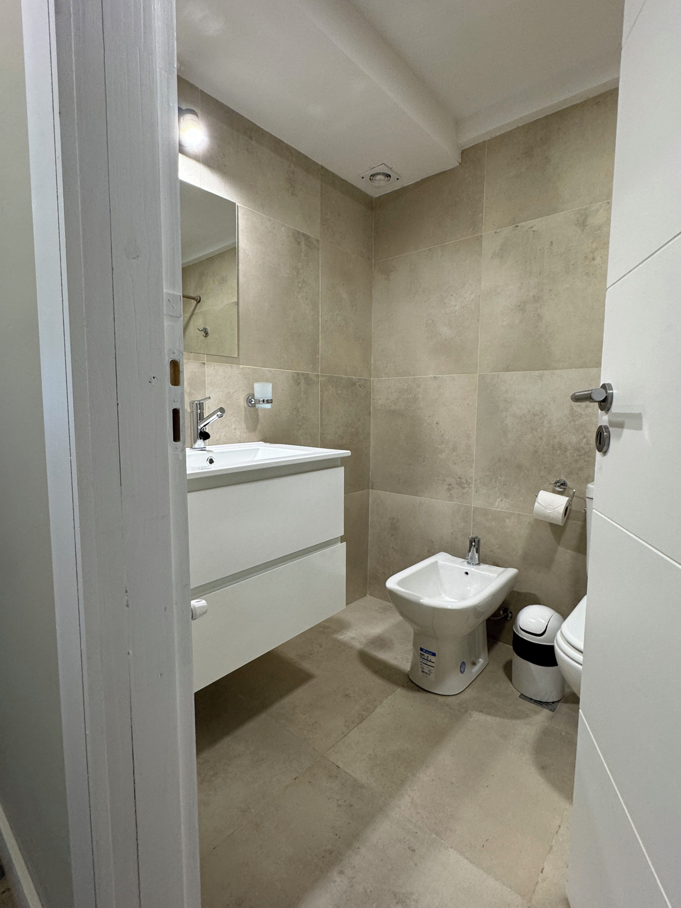 Ein Badezimmer mit Waschbecken, Bidet, Toilette und Spiegel.