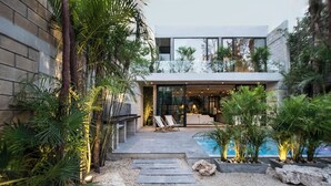 A modern house with a pool, stone steps, and tropical plants. - Hum Living Luxury Villas (Tulum)