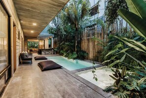 Uma área de piscina moderna ao ar livre com uma espreguiçadeira e um bar.