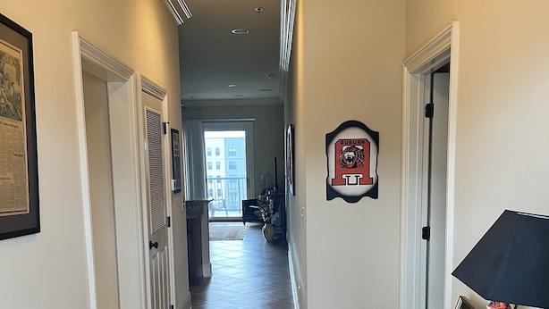 A hallway with a patterned rug, a framed Auburn University logo, and a decorative lamp. - 3 beds 3 baths and amazing views of Jordan Hare!! (Auburn)