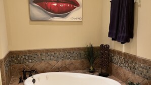 A bathroom with a large bathtub, a mosaic tile border, a faucet, and a towel rack. - 3 beds 3 baths and amazing views of Jordan Hare!! (Auburn)