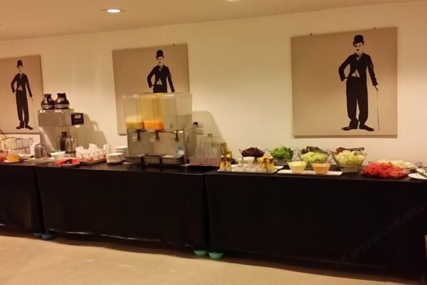 Un'imbandita tavola da buffet con cibi e bevande di vario tipo.
