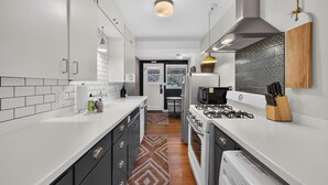 A modern kitchen with white cabinets, a stove, and a microwave. - North Sister - Bungalow Charm, Fireplace, Queen bed, Parking (Bend)