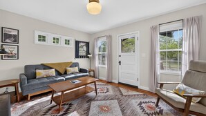 A living room with a sofa, armchair, coffee table, and patterned rugs. - North Sister - Bungalow Charm, Fireplace, Queen bed, Parking (Bend)