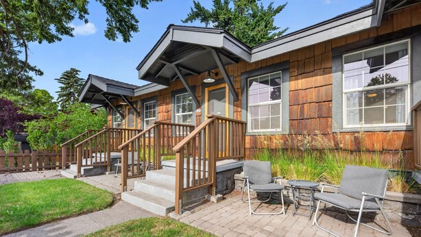 A two-story wooden house with a porch, outdoor seating, and a fenced garden. - Middle Sister - Sweet Bungalow, Queen bed, Parking, Walkable downtown Bend (Bend)