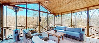 Lakefront retreat with screened sunroom, wood stove, multiple decks, & AC