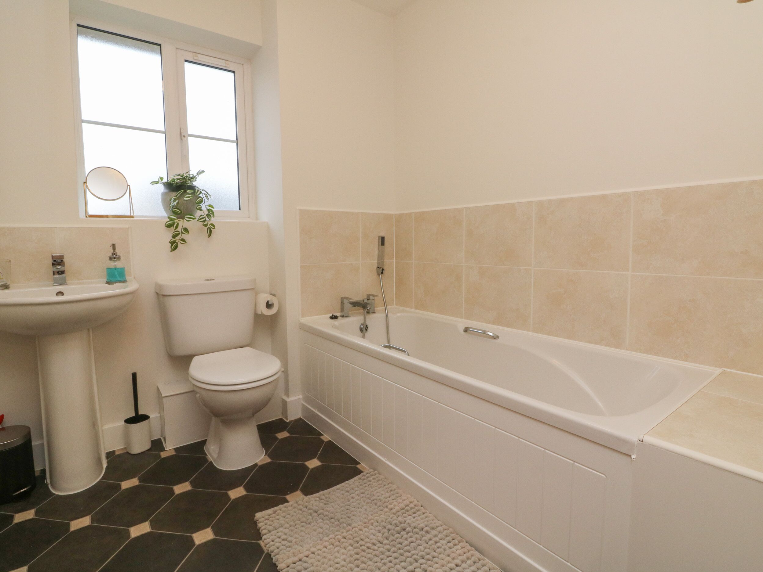 A bathroom with a toilet, sink, and bathtub.