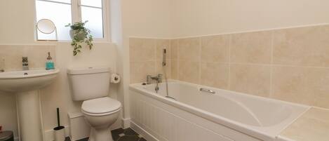 A bathroom with a toilet, sink, and bathtub.