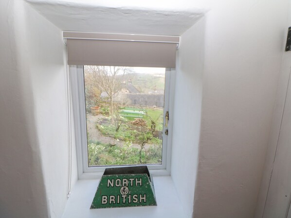 Una finestra con vista su un giardino e un cartello con la scritta 'North of British'.