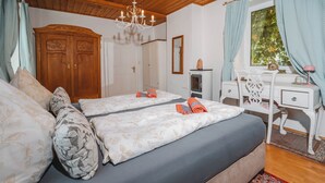 A bedroom with two beds, a wooden wardrobe, a desk, and a chandelier. - Müllers Ferienhaus Salzburgerland (Unken)