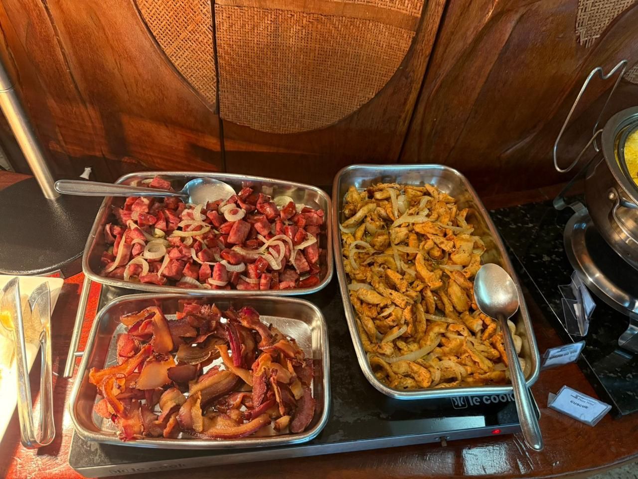 A buffet with various food items including meats and vegetables.