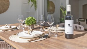 A dining table set with plates, glasses, and a wine bottle. - Apartment in Medina Garden for 4 people | 201 (Puerto Banús - Marbella)