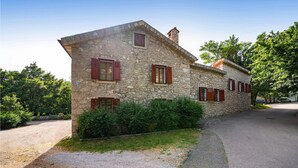 A stone building with multiple windows and a gravel driveway.