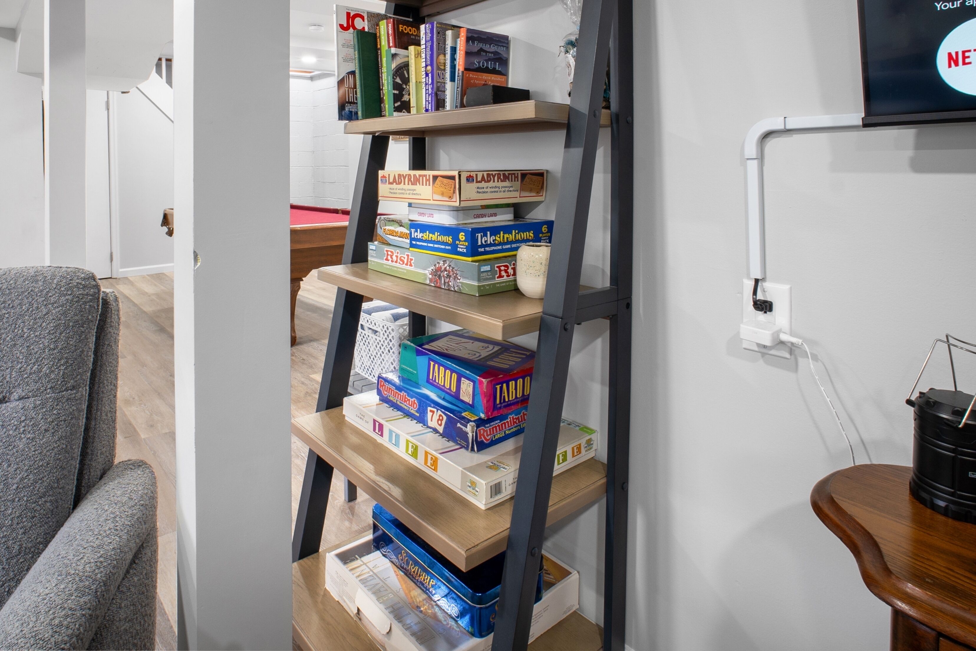 Une bibliothèque contenant divers jeux de société et livres.
