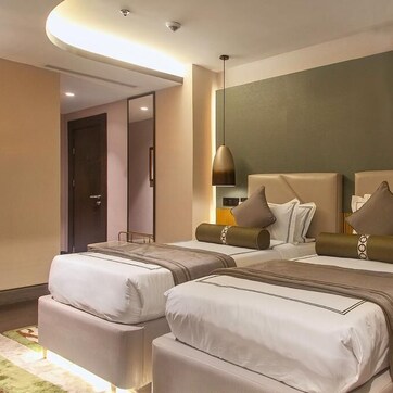 Una habitación de hotel con dos camas, un espejo, una mesita de noche y una lámpara.