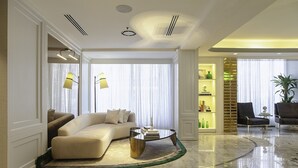 A modern living room with a beige sofa, a glass coffee table, and a marble floor. - The Delborough Lagos (Lagos)